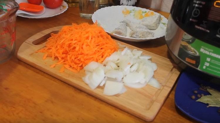 Wir schneiden die Zwiebeln in halbe Ringe und drei Karotten auf einer Reibe.