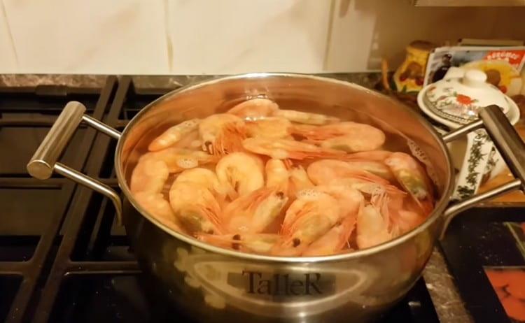 Wenn Sie gekochte, gefrorene Garnelen gekauft haben, gießen Sie sie einfach 3 Minuten lang in kochendes Wasser.