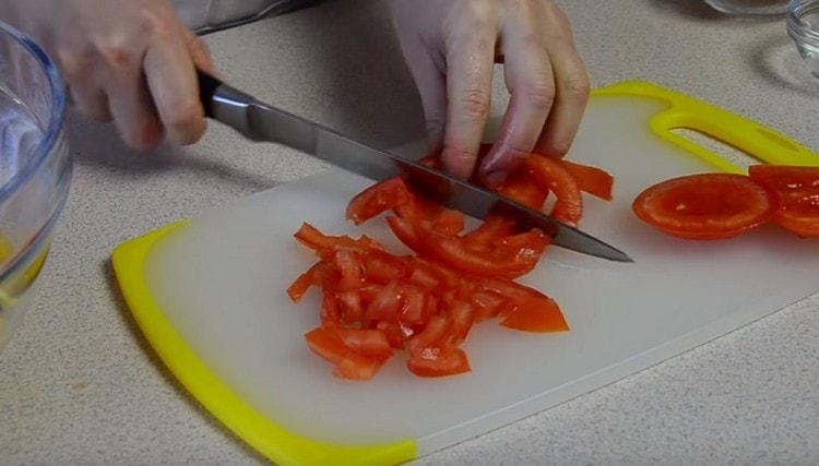 Pomidorą taip pat supjaustome kubeliu, prieš tai pašalindami minkštą daržovės dalį.