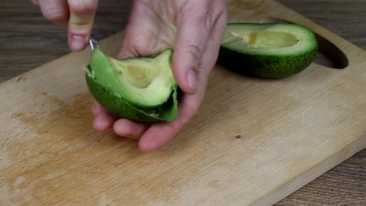 Tagliare l'avocado a metà, estrarre la pietra e quindi estrarre la polpa dalla buccia con un cucchiaino.