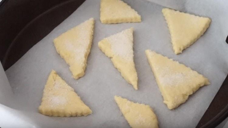 βάζετε τα μπισκότα σε ένα φύλλο ψησίματος που καλύπτεται με χαρτί και τα βάζετε στο φούρνο.