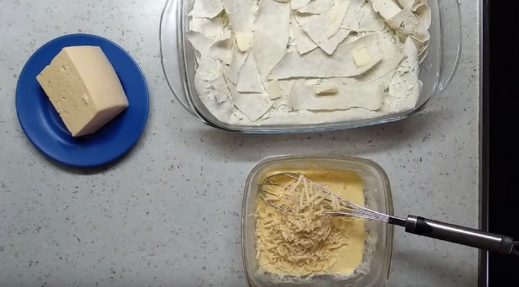 Pasiruošimas pyrago įdarui iš kiaušinių. grietinės ir tarkuoto sūrio.