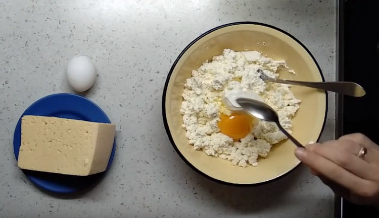 Į varškę įmaišykite kiaušinį ir grietinę.