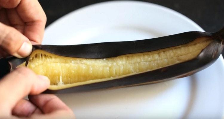 Mes išimame iš orkaitės keptą bananą ir nedelsdami supjaustome žievelę.