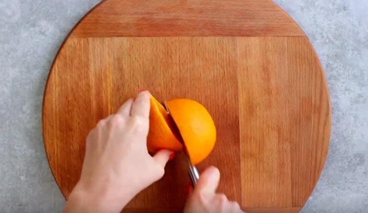 Измийте портокала и го нарежете наполовина.