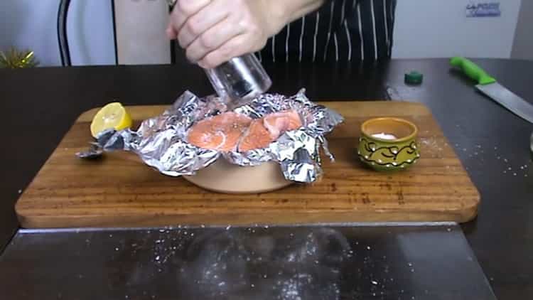 Um Forellensteak im Ofen zuzubereiten, geben Sie Pfeffer auf den Fisch