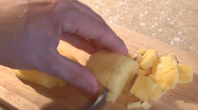 Tagliare a pezzetti le patate e le carote.