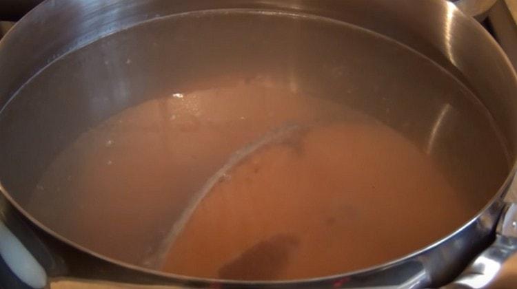 За да приготвите супата, сложете пържолите от червена риба във водата и поставете да се готви.
