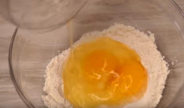 Разбиваме две яйца в брашно.