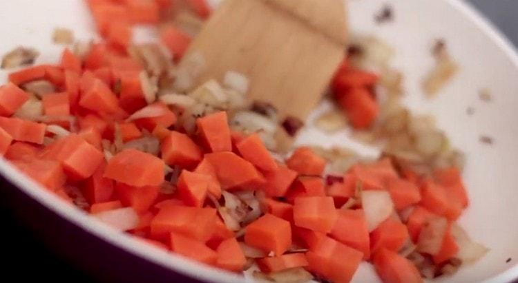 Fügen Sie die gewürfelte Karotte der Zwiebel hinzu.