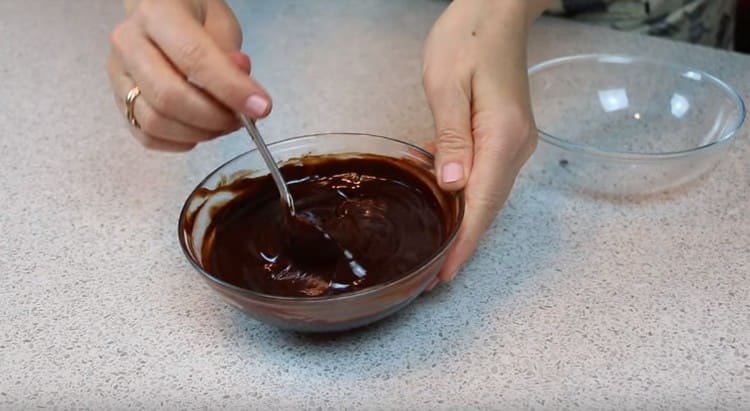 نقوم بصنع الثلج عن طريق إذابة الشوكولاتة بالزبدة في الميكروويف ونخلطها.
