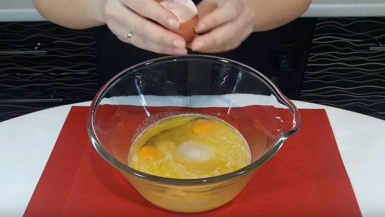 Wir schlagen zwei Eier für Zucker und Butter aus, mischen.