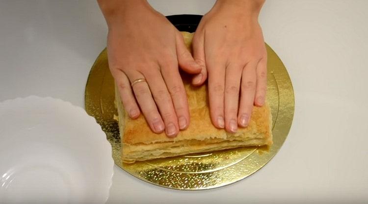 Schiacciamo la torta con le mani, rimuoviamo le briciole esfoliate dall'alto.
