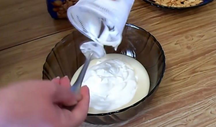 Készítsen krémet tejfölből és sűrített tejből, keverve őket.
