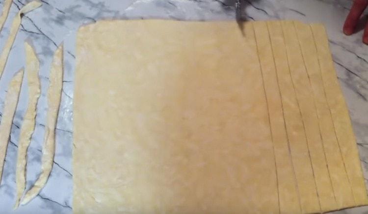 Нарежете слой тесто на ленти със същата дължина.