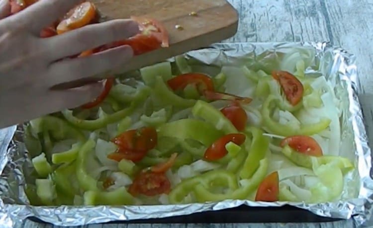 Στην κορυφή του κρεμμυδιού, απλώστε πρώτα την πιπεριά και στη συνέχεια τις ντομάτες.