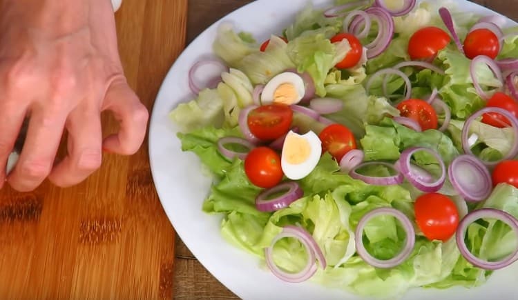 In den Salat hartgekochte und in zwei Hälften geschnittene Wachteleier geben.