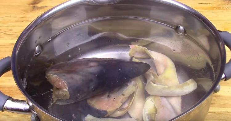 Wir verteilen den Kopf von rosa Lachs in einer Pfanne mit Wasser, bringen ihn zum Kochen, entfernen den Schaum.