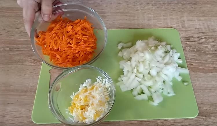 Auf einer Reibe reiben wir ein gekochtes hartgekochtes Ei, Karotten, Zwiebeln.