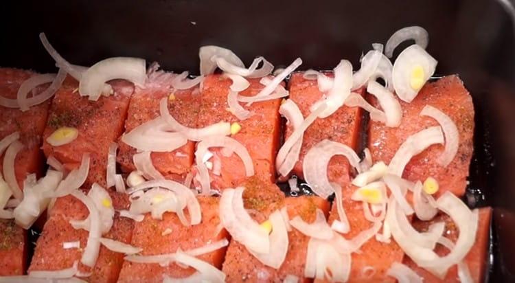 Cospargere il pesce con semianelli di cipolla tagliati a fettine sottili.