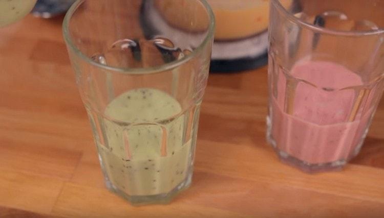 Gießen Sie in ein Glas die erste Schicht Grün und den zweiten rosa Smoothie.