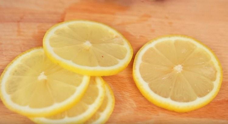 Zitrone waschen und in Kreise schneiden.