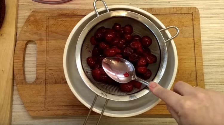Inclinare le ciliegie su un setaccio per drenare il succo.