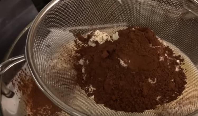 Пресейте брашното и какаото в яйчената маса.