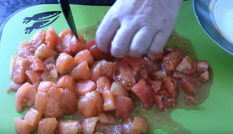 Geschälte Tomaten in Stücke schneiden.