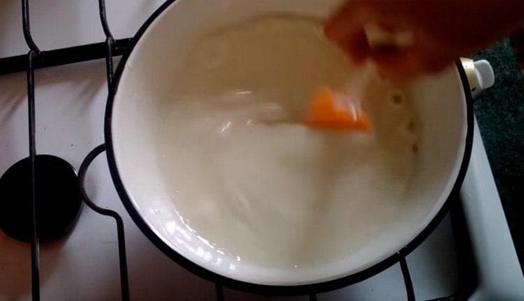Die Vanillepuddingbasis der Creme kochen, bis sie eingedickt ist.