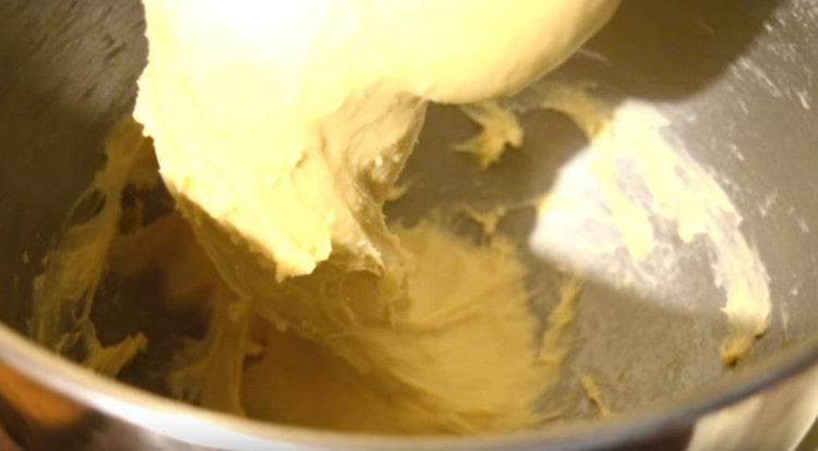 Do těsta přidejte změkčené máslo a dobře promíchejte.