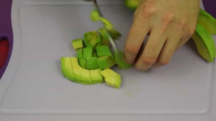 Per preparare panini con avocado e pesce rosso, tagliare l'avocado