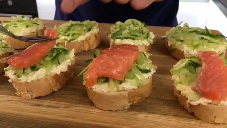 Sammeln Sie alle Zutaten auf einem Baguette, um Sandwiches mit rotem Fisch zuzubereiten