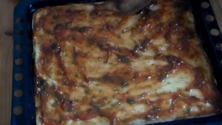 Per preparare una pizza veloce in forno, ungere l'impasto con la salsa