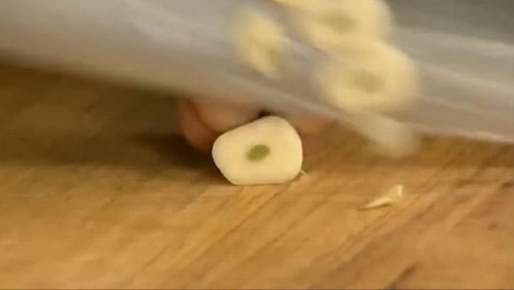 Σύμφωνα με τη συνταγή, για να προετοιμάσει το φιλέτο μερλούκιου, ψιλοκόψτε το σκόρδο
