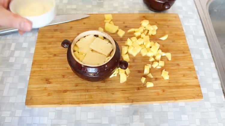 Zum Kochen von Rindfleisch in Töpfen mit Kartoffeln in den Ofen die Butter geben
