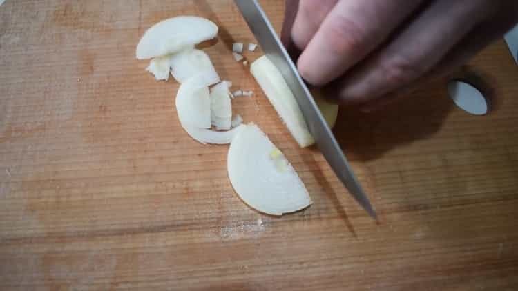 Per cucinare lo stufato di manzo con le verdure, tagliare la cipolla