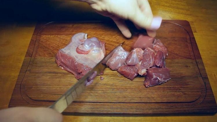 Um Rindergulasch in einem Slow Cooker zuzubereiten, hacken Sie das Fleisch