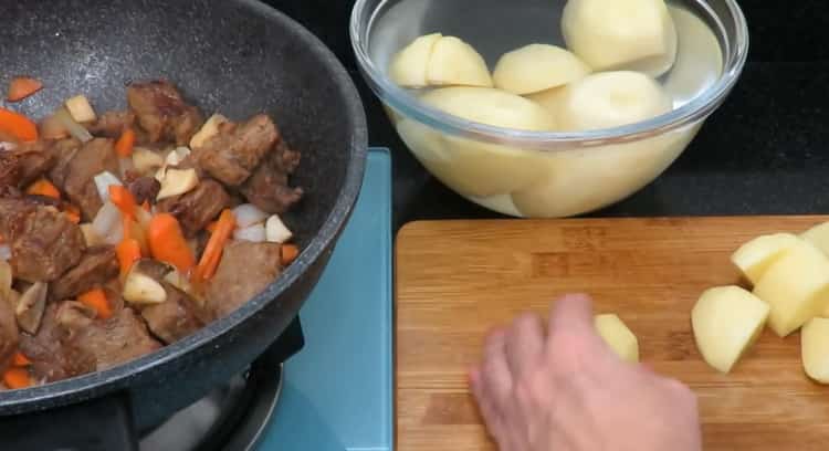 لطهي لحم البقر المشوي مع البطاطا. يقطع البطاطس