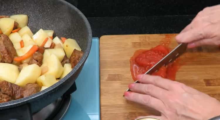 Pro vaření pečeného hovězího masa se bramborami. nakrájejte rajčata