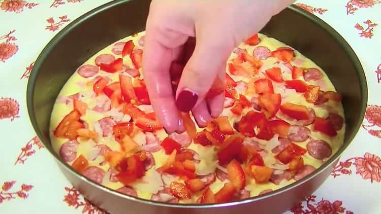 За да направите желирана пица във фурната, нарежете доматите