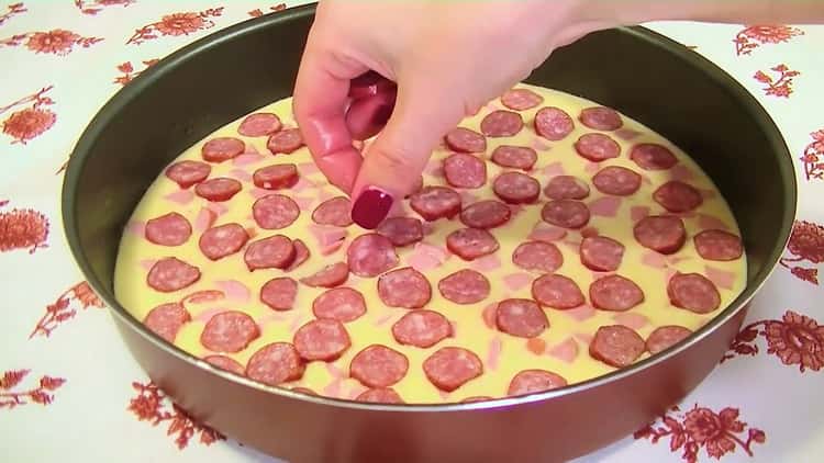 Um die gelierte Pizza im Ofen zuzubereiten, legen Sie die Wurst hinein