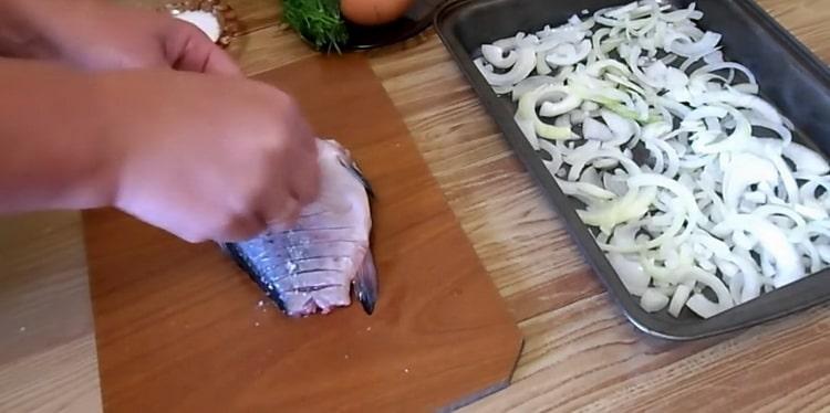 За да направите кръстосан шаран в заквасена сметана, направете разрези върху рибата