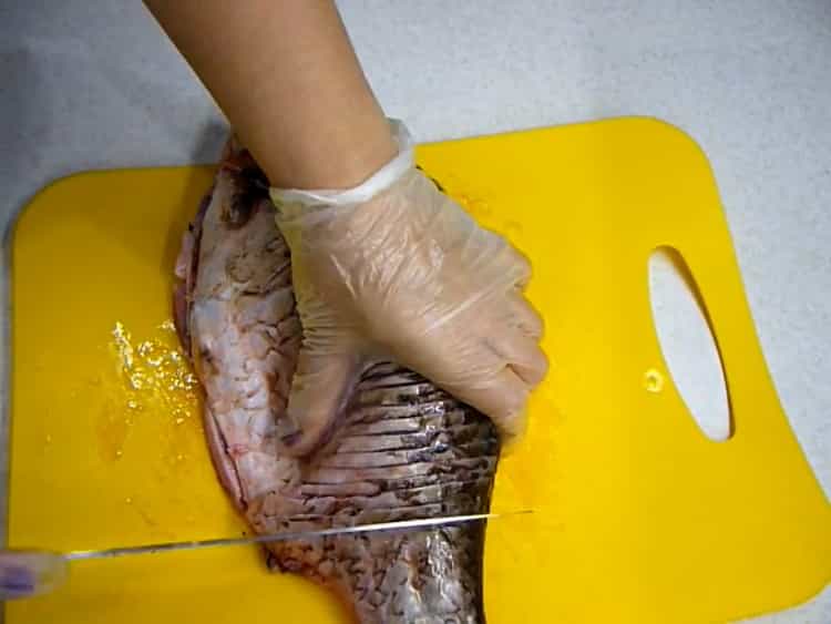 Per preparare carpe crociate fritte, praticare incisioni nel pesce
