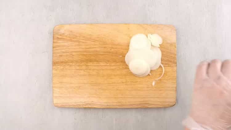 Zum Garen von Kaugummilachs im Ofen die Zwiebeln nach dem Rezept hacken
