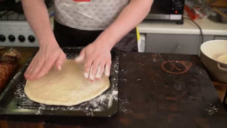 Klasszikus pizza elkészítéséhez tegye a tésztát egy formába