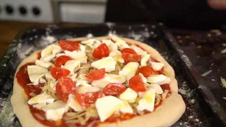 Klasszikus pizza elkészítéséhez tegye a tölteléket a tésztára