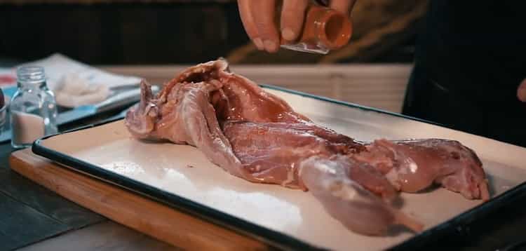 Cucinare l'intero coniglio nel forno. salare la carne