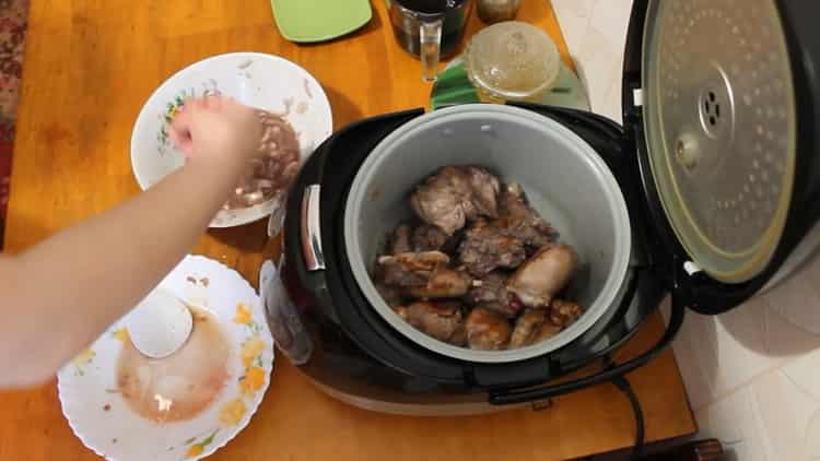 Bereiten Sie die Zutaten vor, um ein Kaninchen in einem Slow Cooker in einer Sauce aus saurer Sahne zuzubereiten