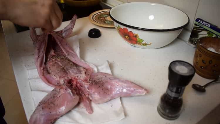 Per preparare il coniglio in un foglio nel forno, strofinare il coniglio con le spezie
